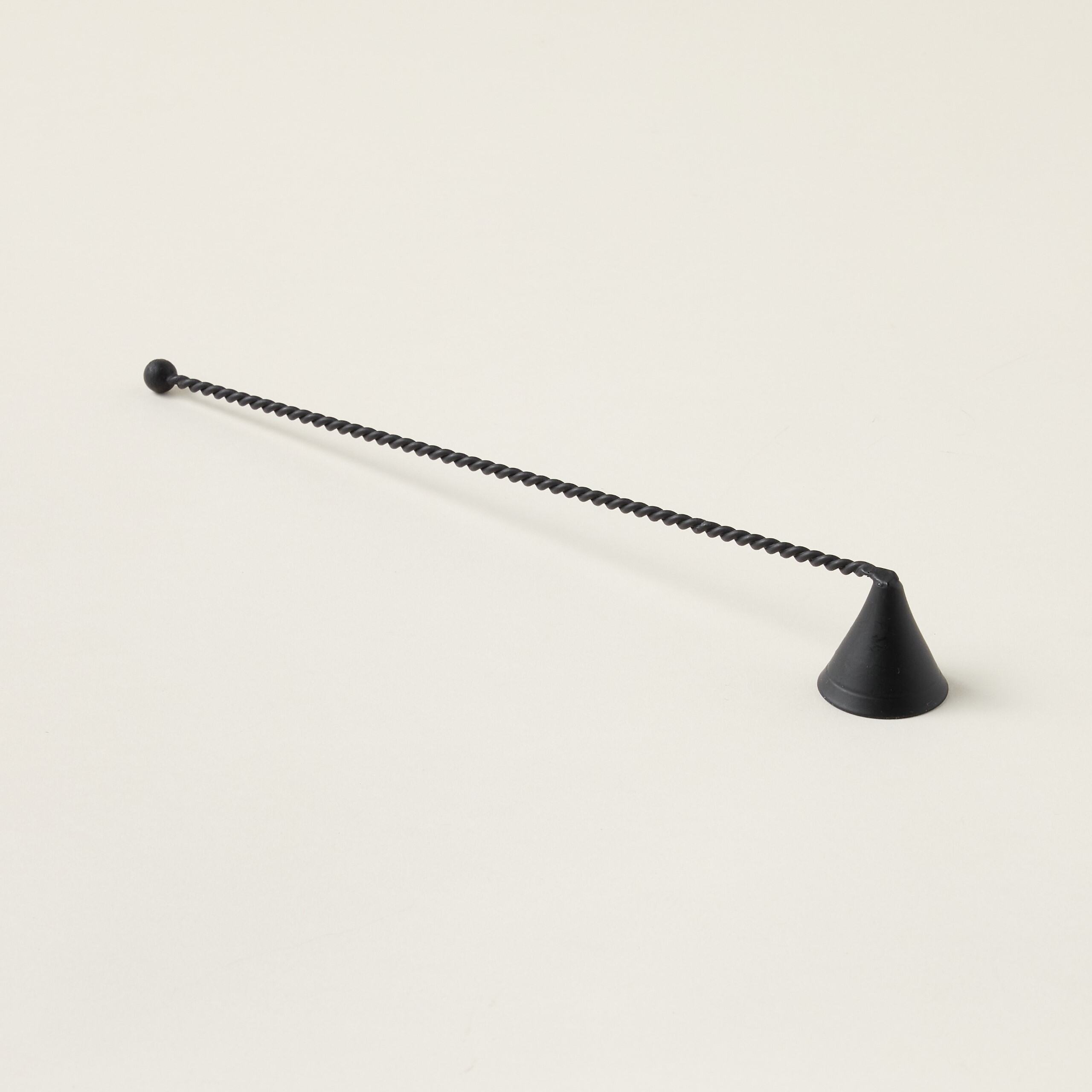 Artisan-inspired metal candle snuffer with a unique twisted handle and a modern design.