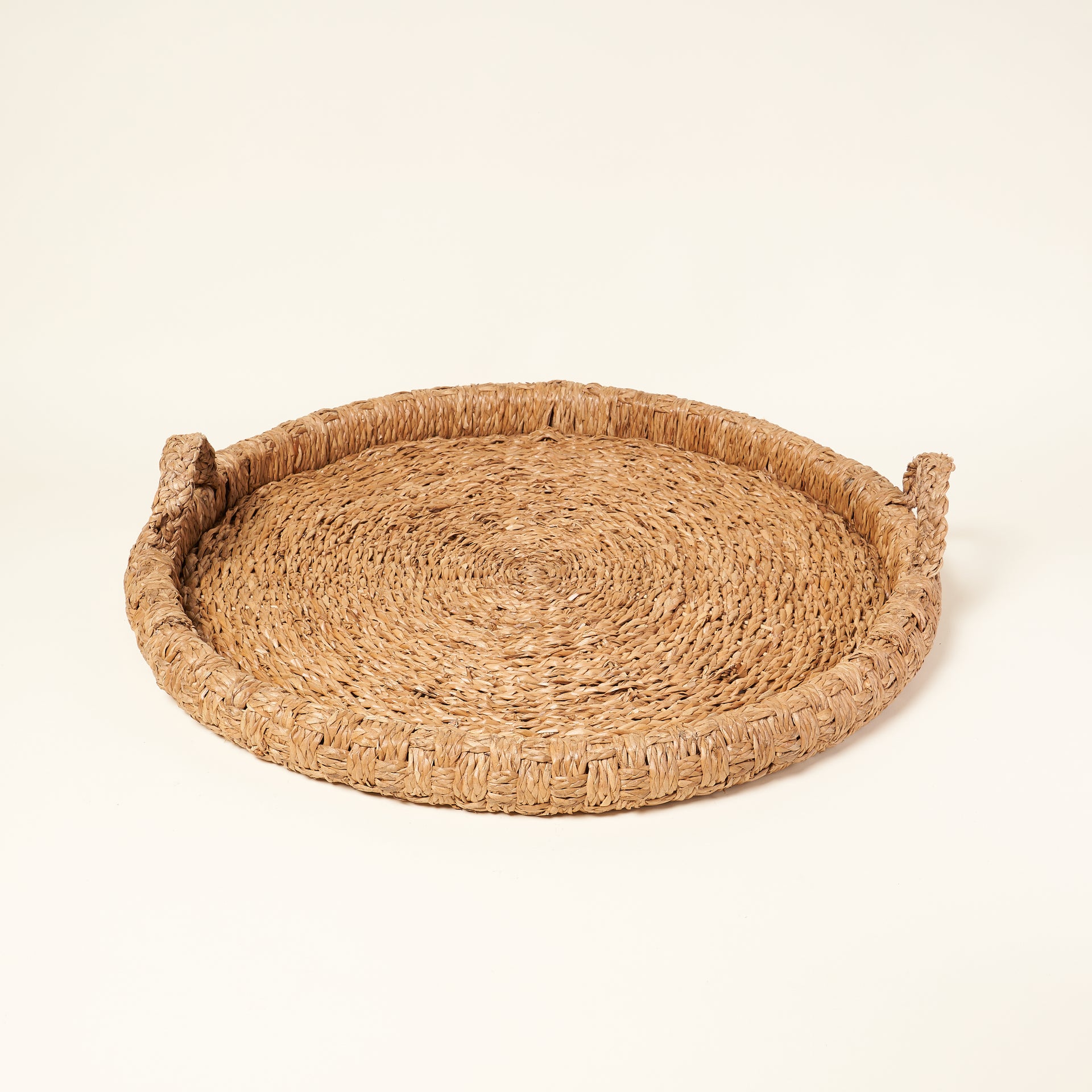 Braided round bankuan tray with a natural texture.