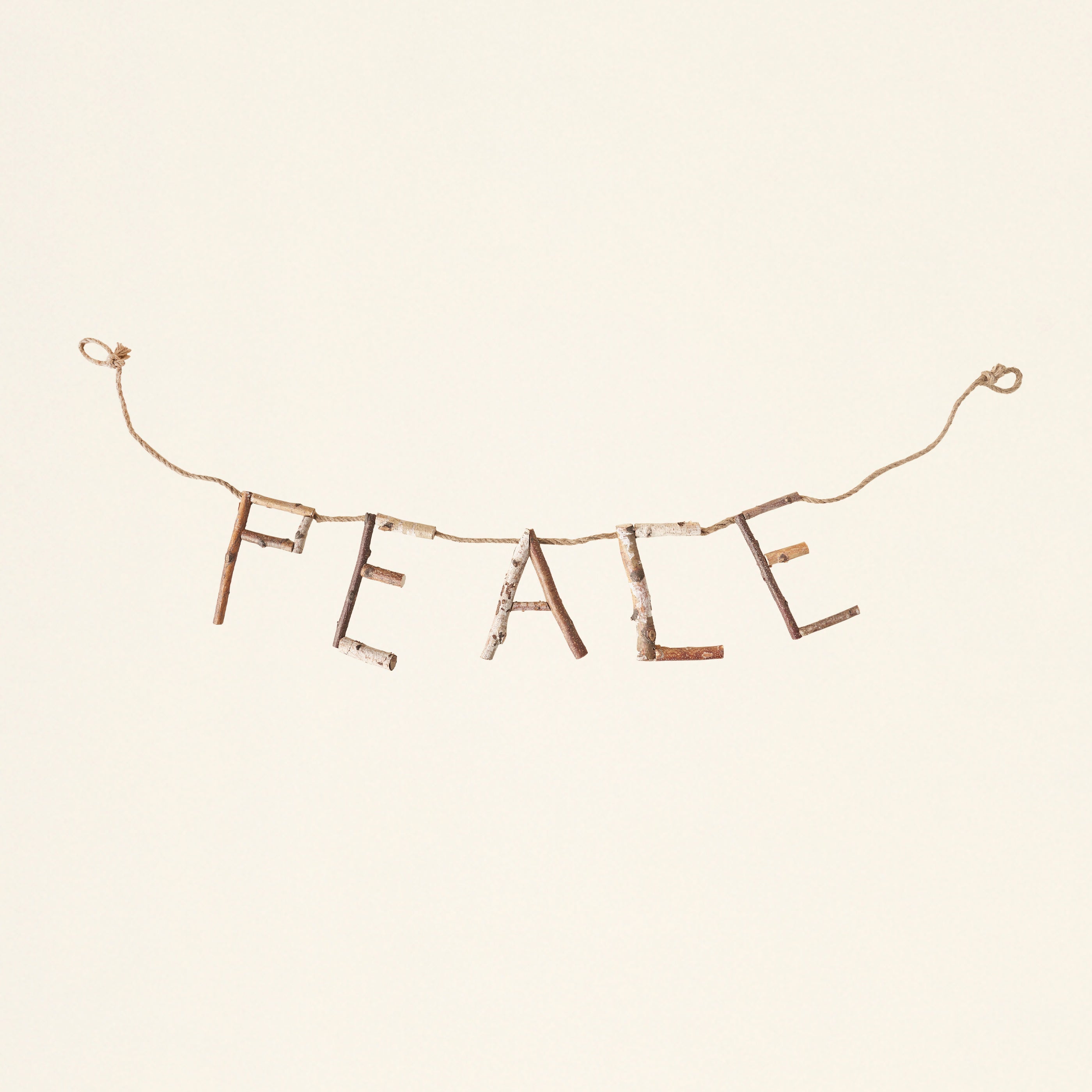 A decorative banner with the word "peace" cut from natural birch wood.