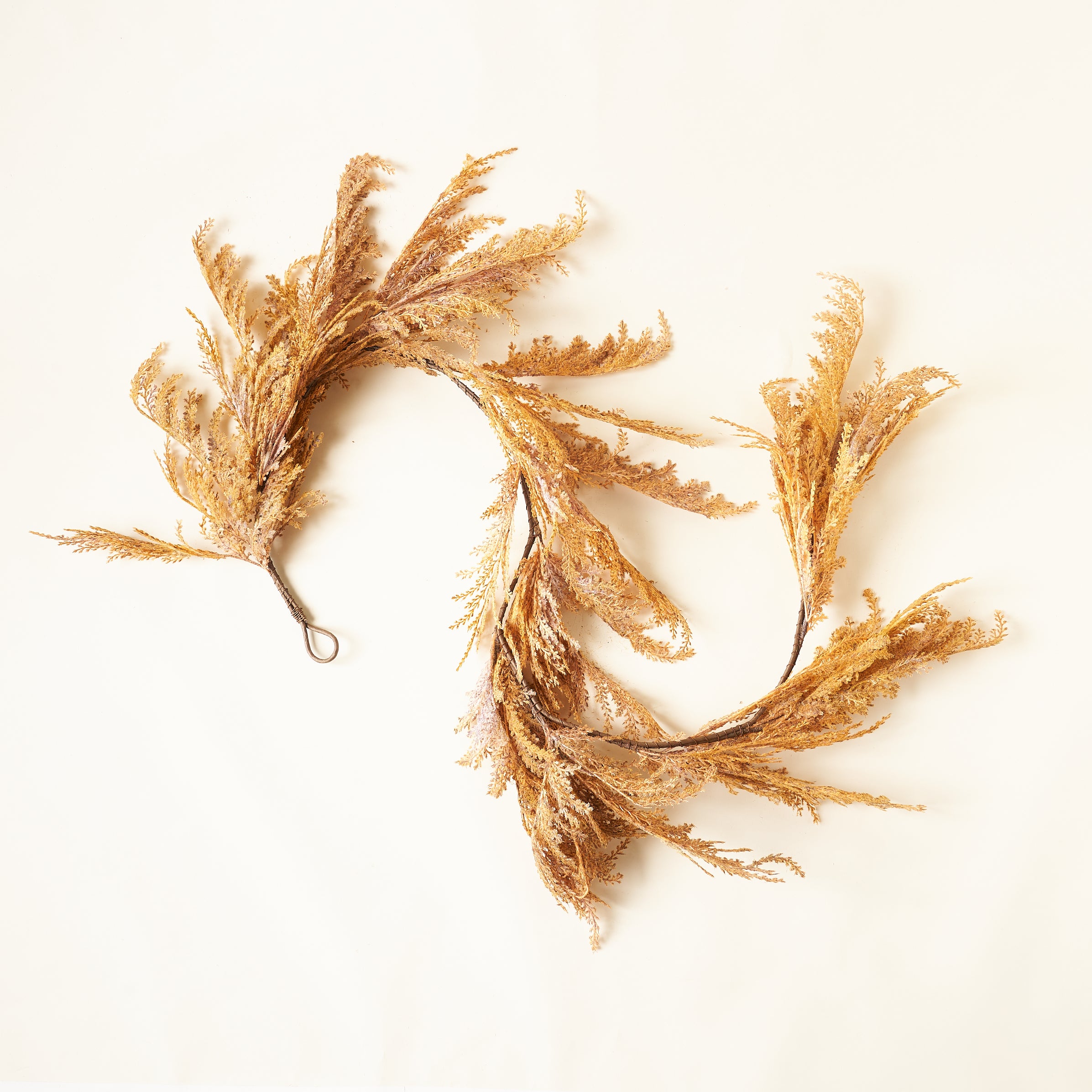 A decorative garland with faux pampas grass sprigs.