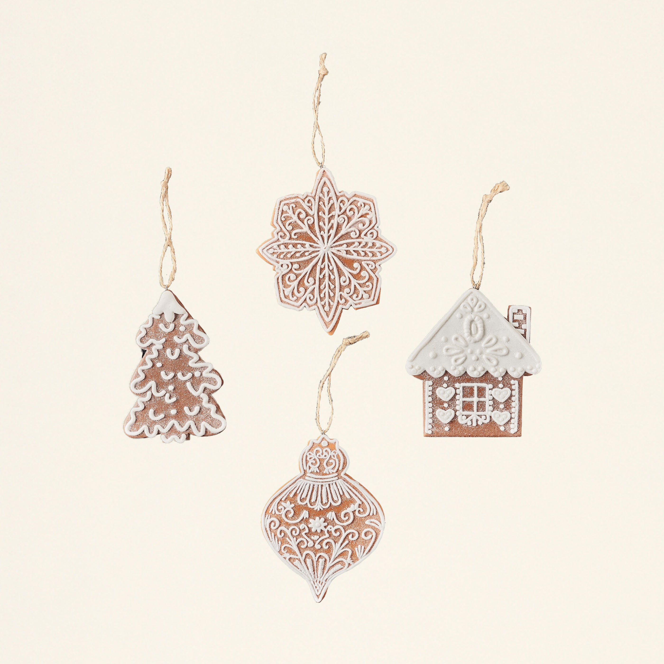 A set of four gingerbread-shaped ornaments made from wheat clay, each with a different pattern.