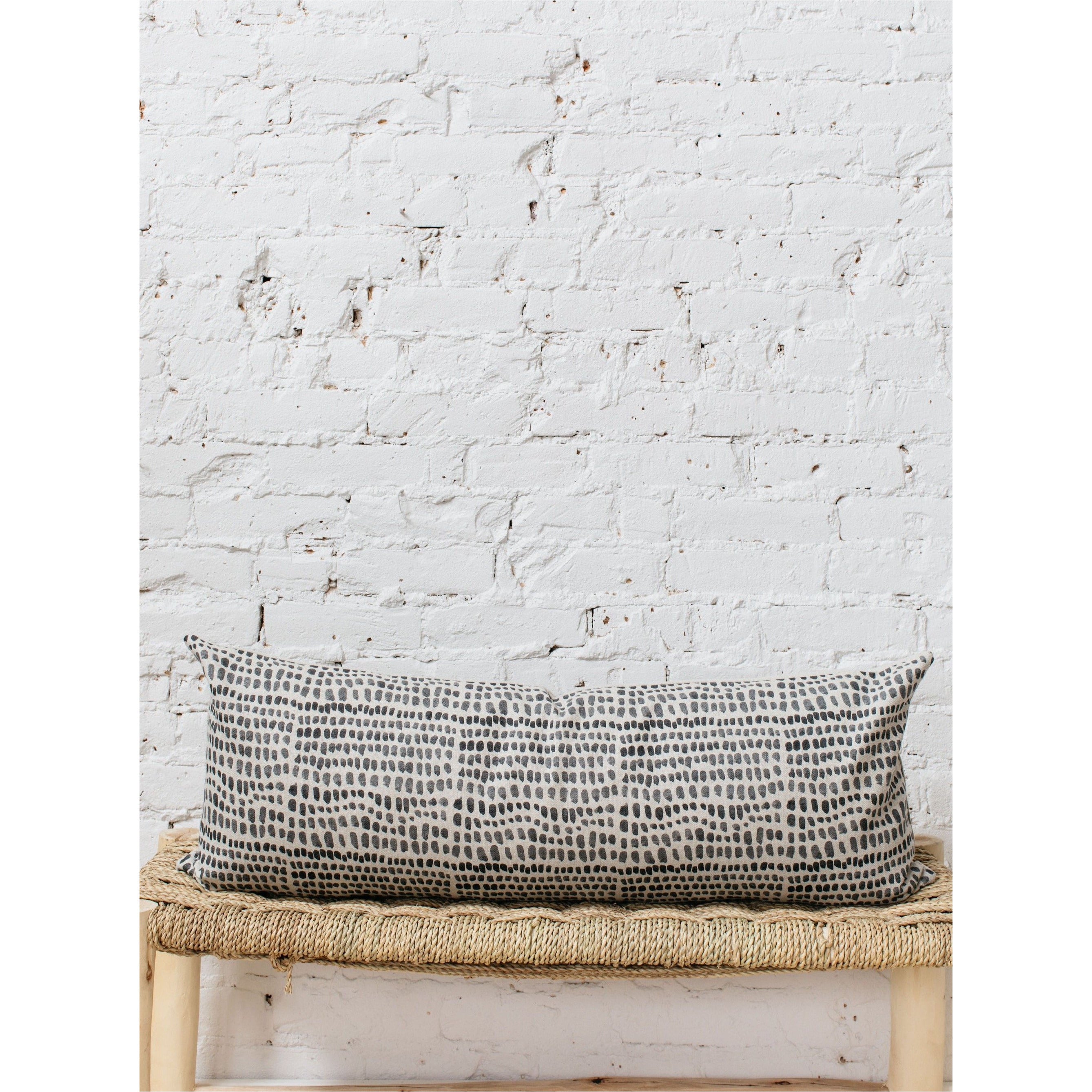 A large lumbar pillow cover in a deep coal color, displayed flat to show its plush texture and simple, clean design.