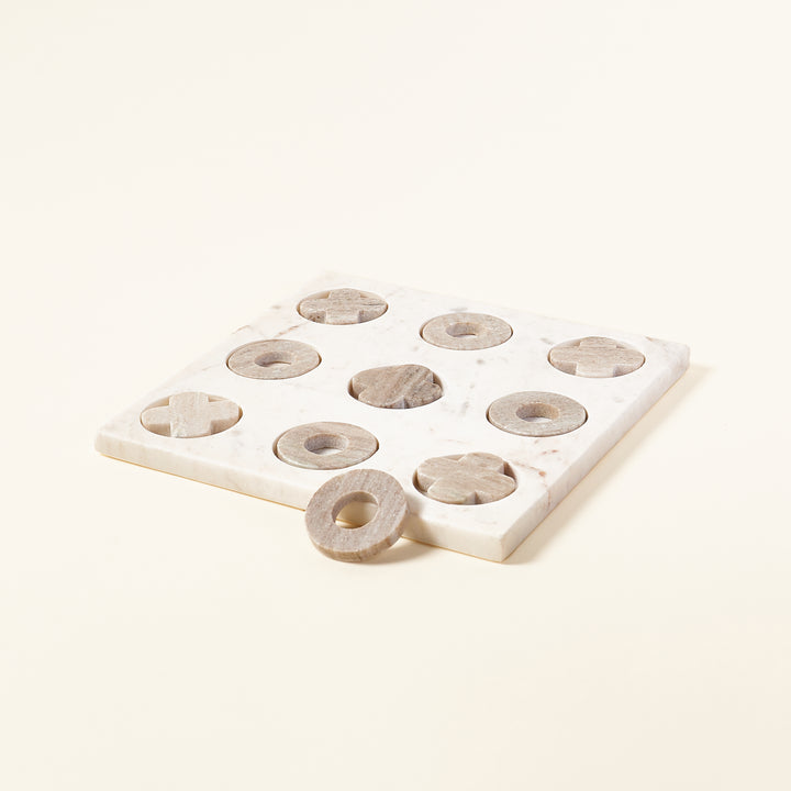 White marble tic-tac-toe game board with grey marble pieces.