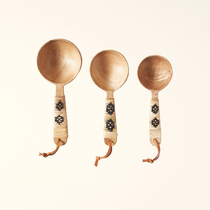 Set of three wooded scoops with rattan-wrapped handles.