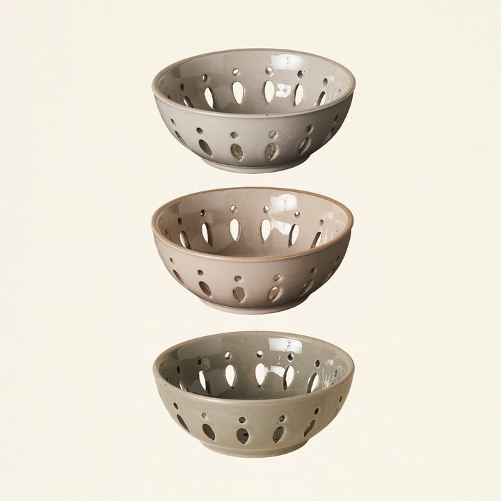 Three stoneware berry bowls in different colors.