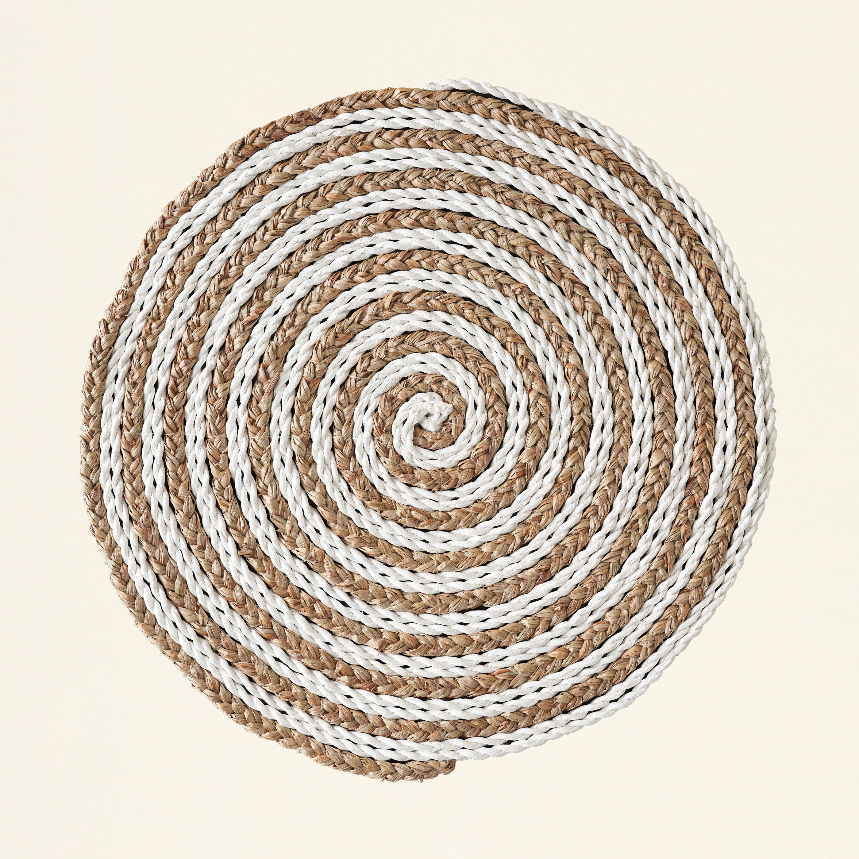A two-toned, intricately woven place mat.