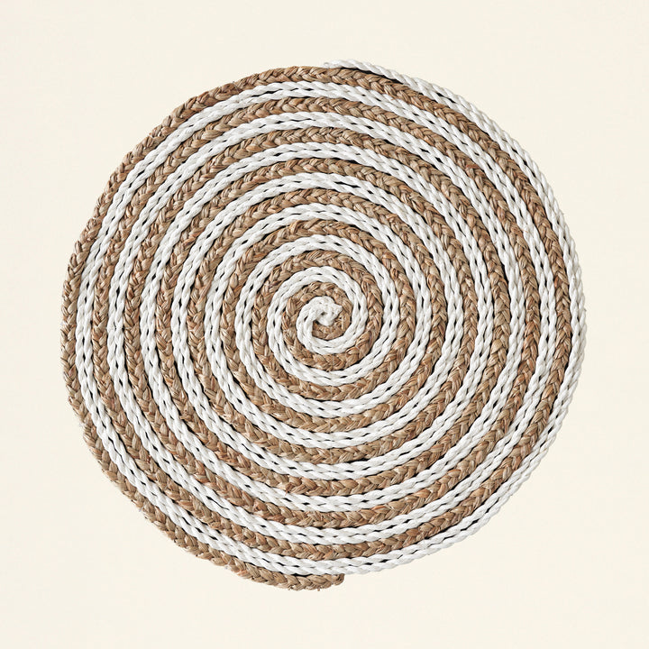 A two-toned, intricately woven place mat.