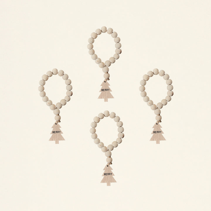 A set of four napkin rings made from wood bead garlands.