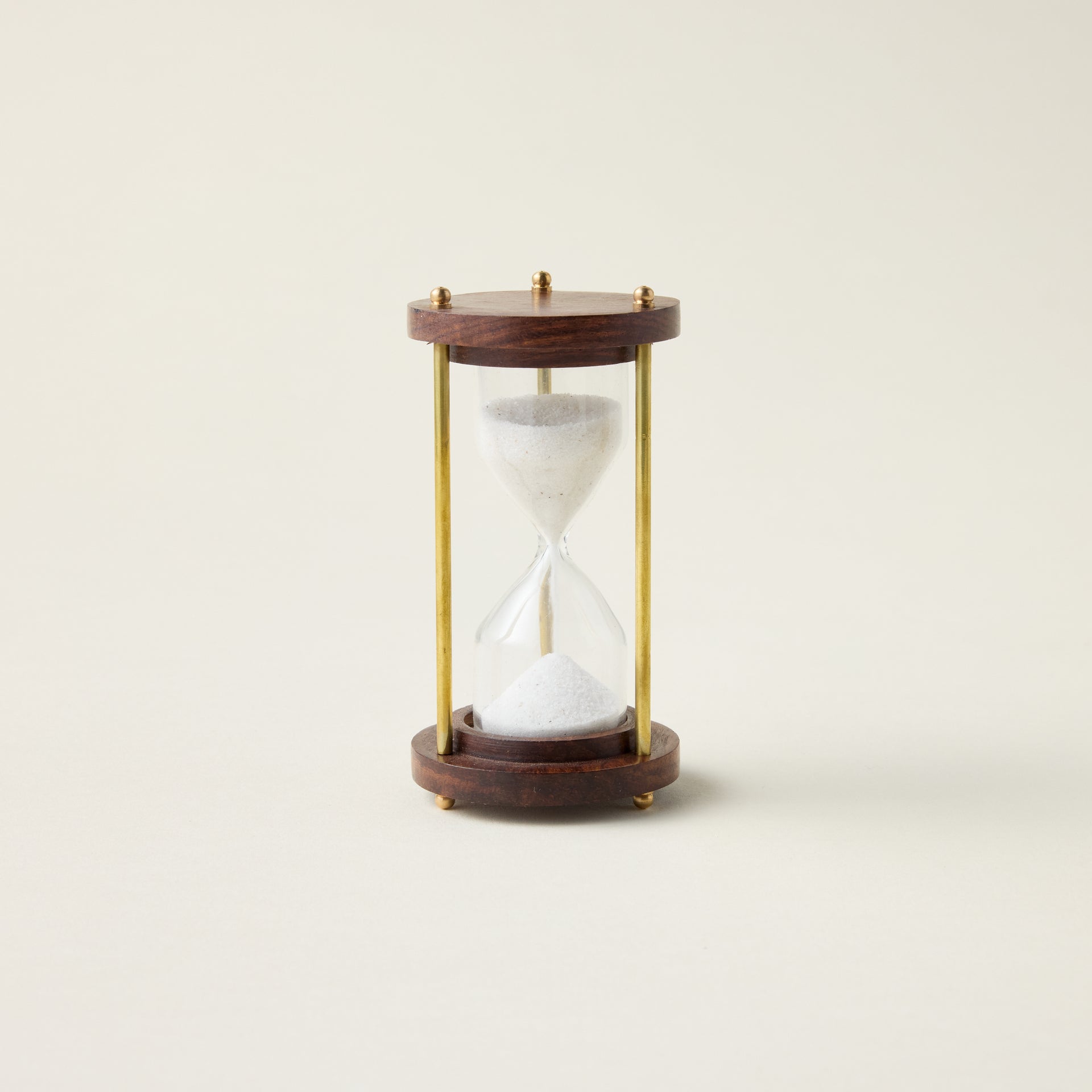 Antique hourglass with a solid wood and brass frame, styled as a timeless and sophisticated decor accent.
