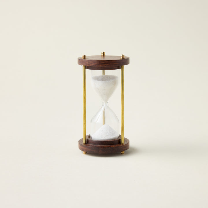 Antique hourglass with a solid wood and brass frame, styled as a timeless and sophisticated decor accent.