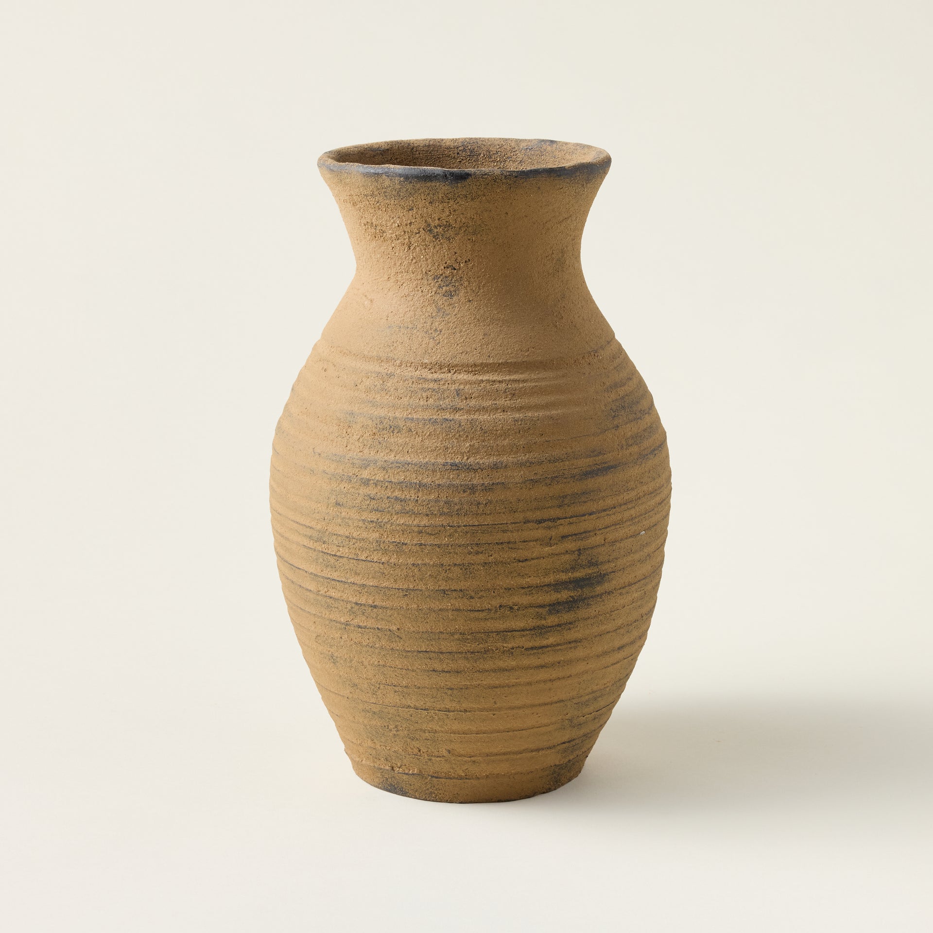 Handcrafted Avery vase with a natural texture and flared opening in a distressed taupe finish.