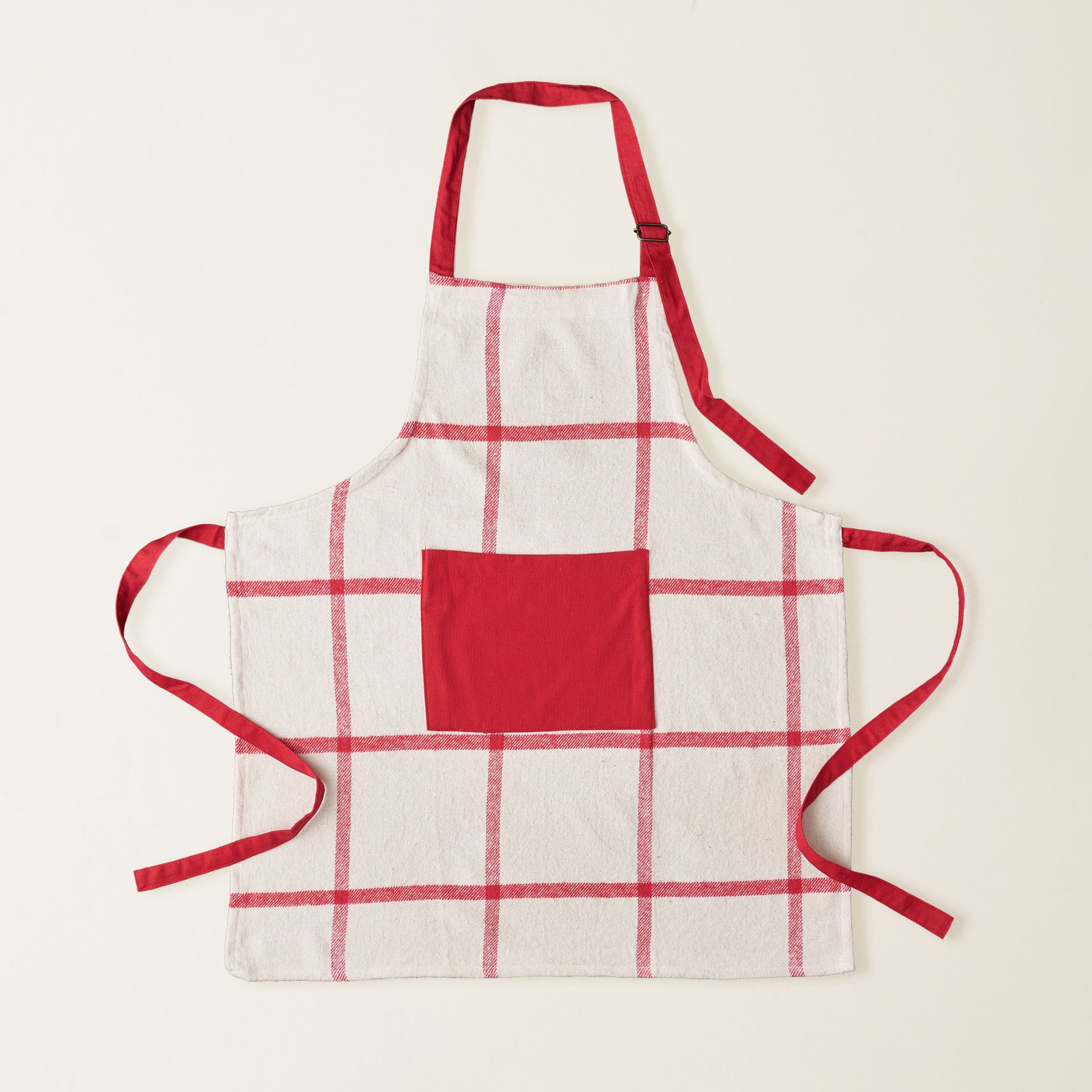 A cotton flannel apron with a red and white candy cane pattern.