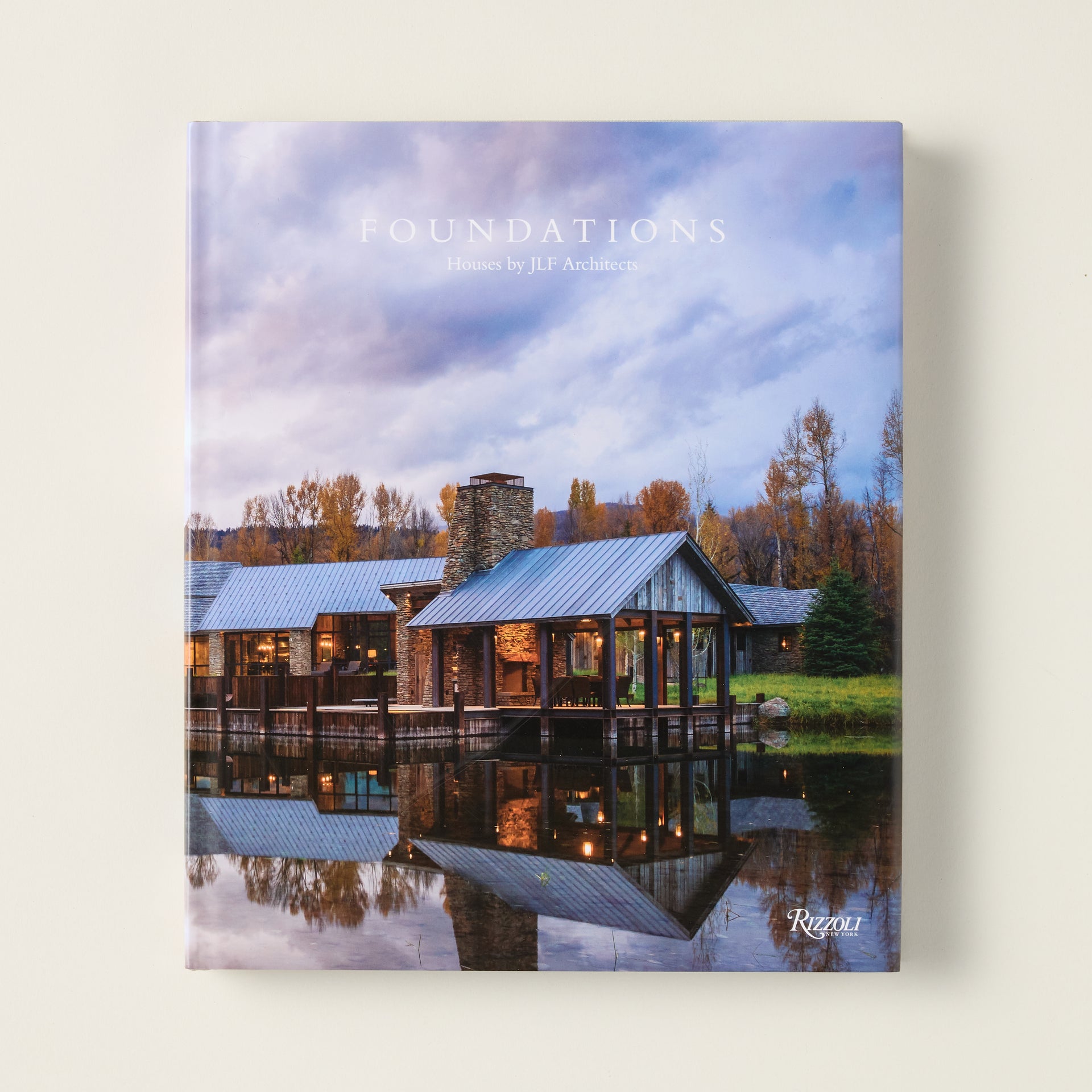 The cover of the "Foundations" book, showing a home by JLF Architects that blends seamlessly with the natural landscape.