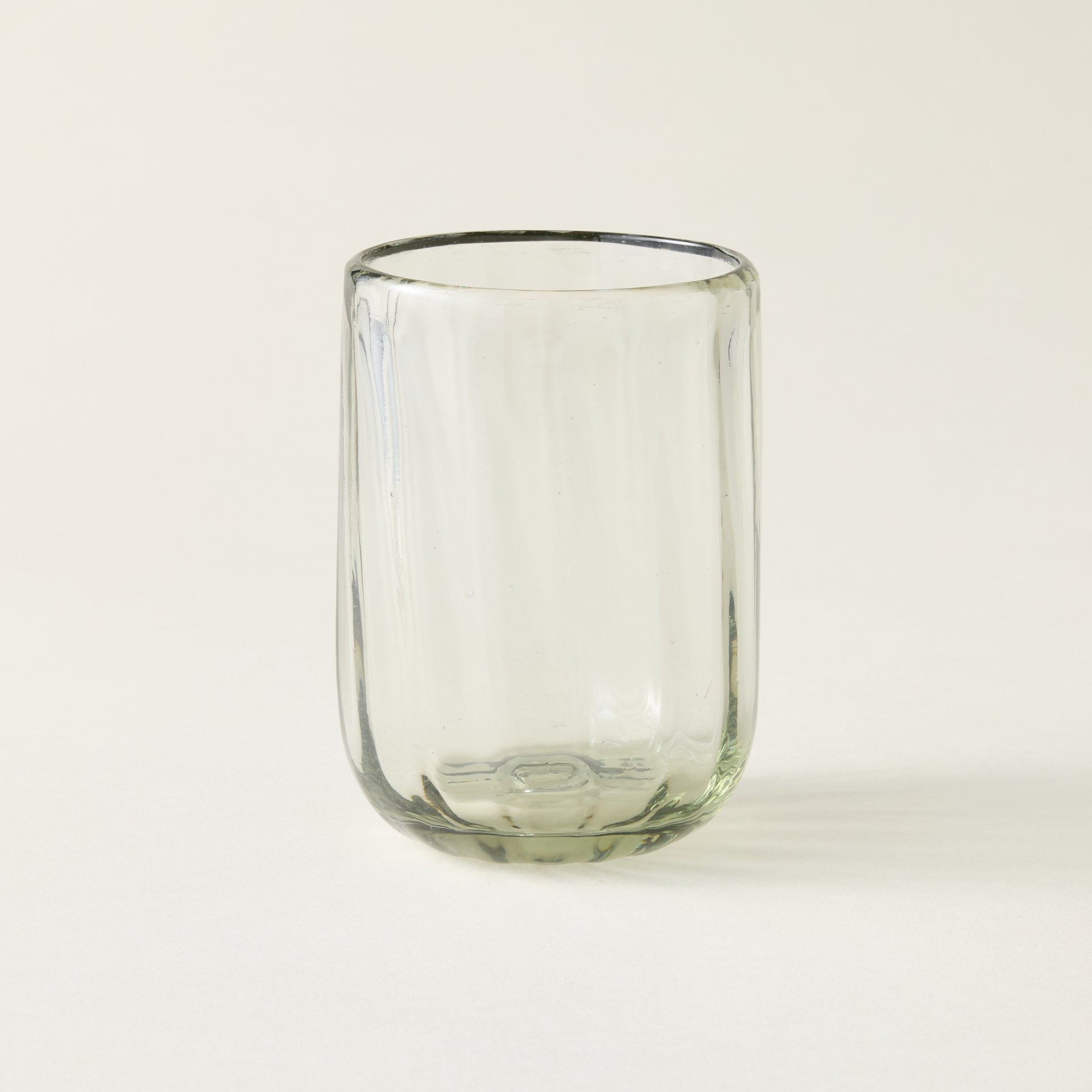 Handblown fluted tumbler crafted from recycled glass with air bubbles and an artisanal feel.