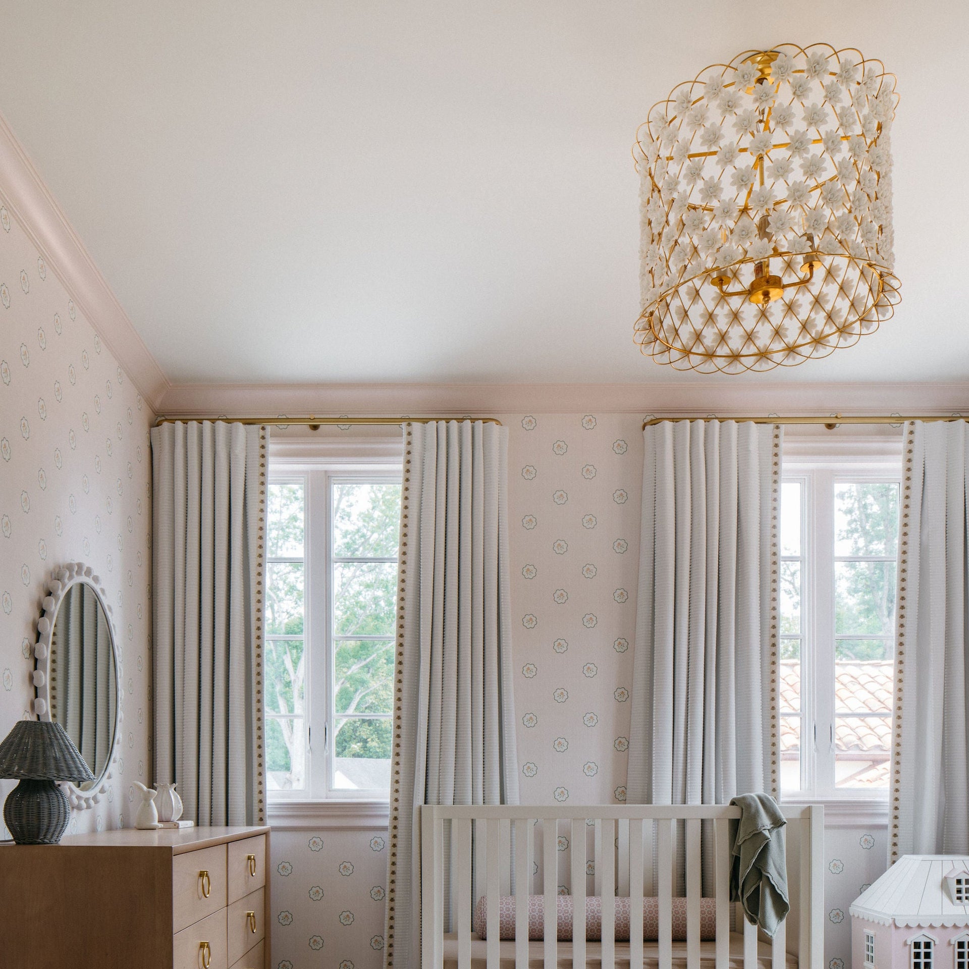 Nursery room with crib, ottoman, dresser, and decorative elements.