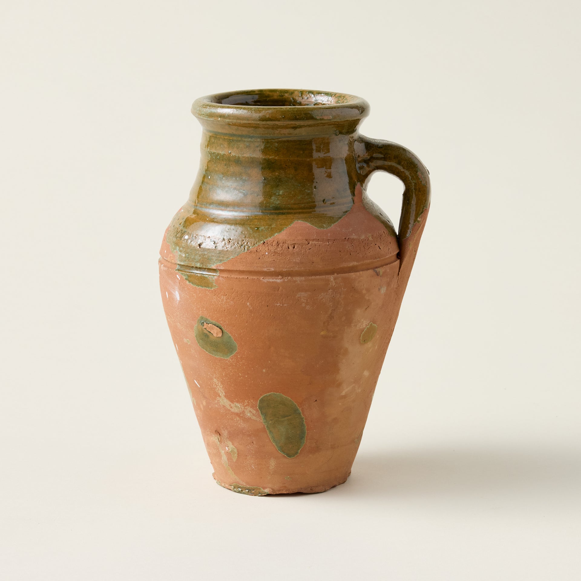 Vintage mini olive jar with a unique patina and marks of age, showcasing its authentic Mediterranean history.