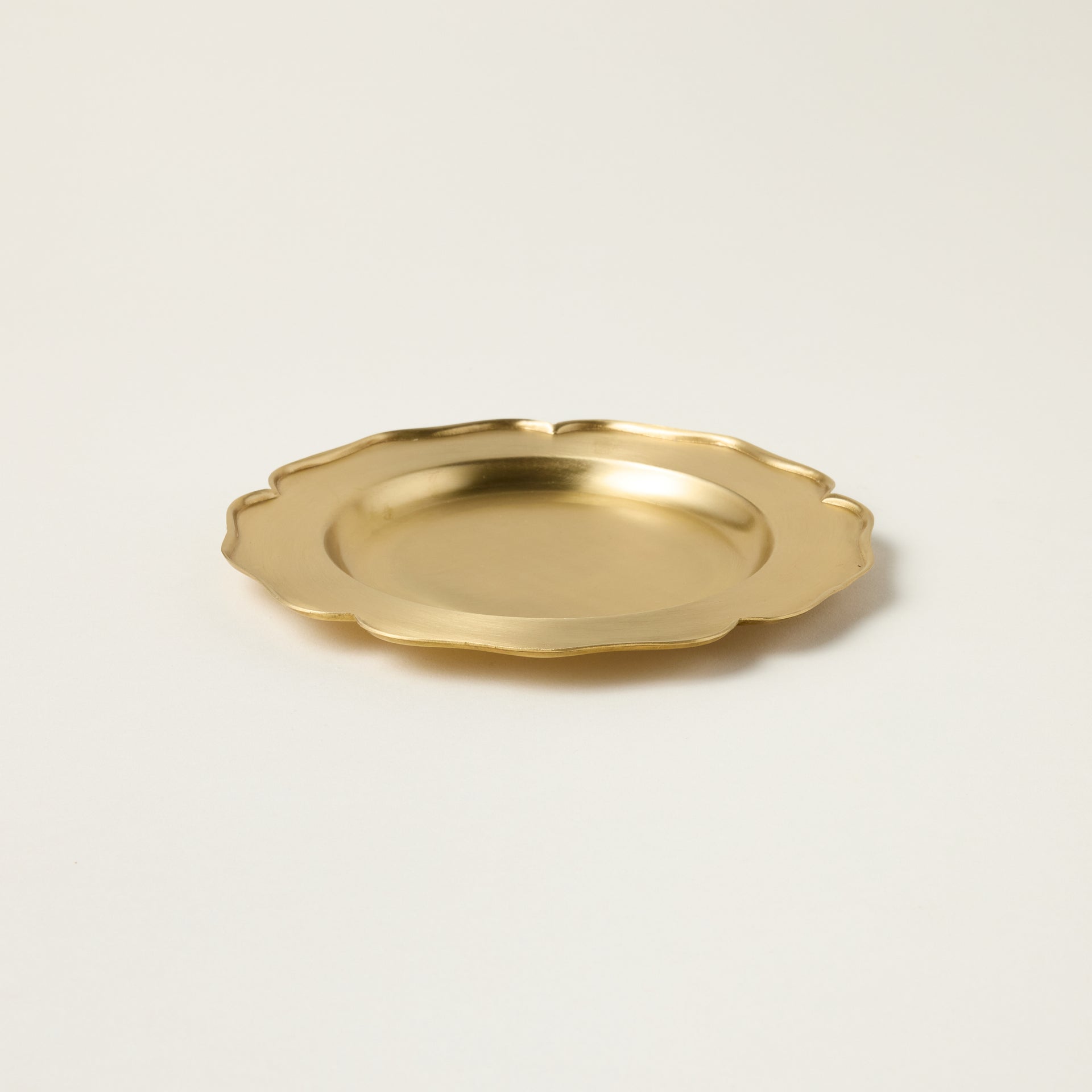 Vintage-inspired petite brass tray with a patina finish, used as a decorative catchall for jewelry.