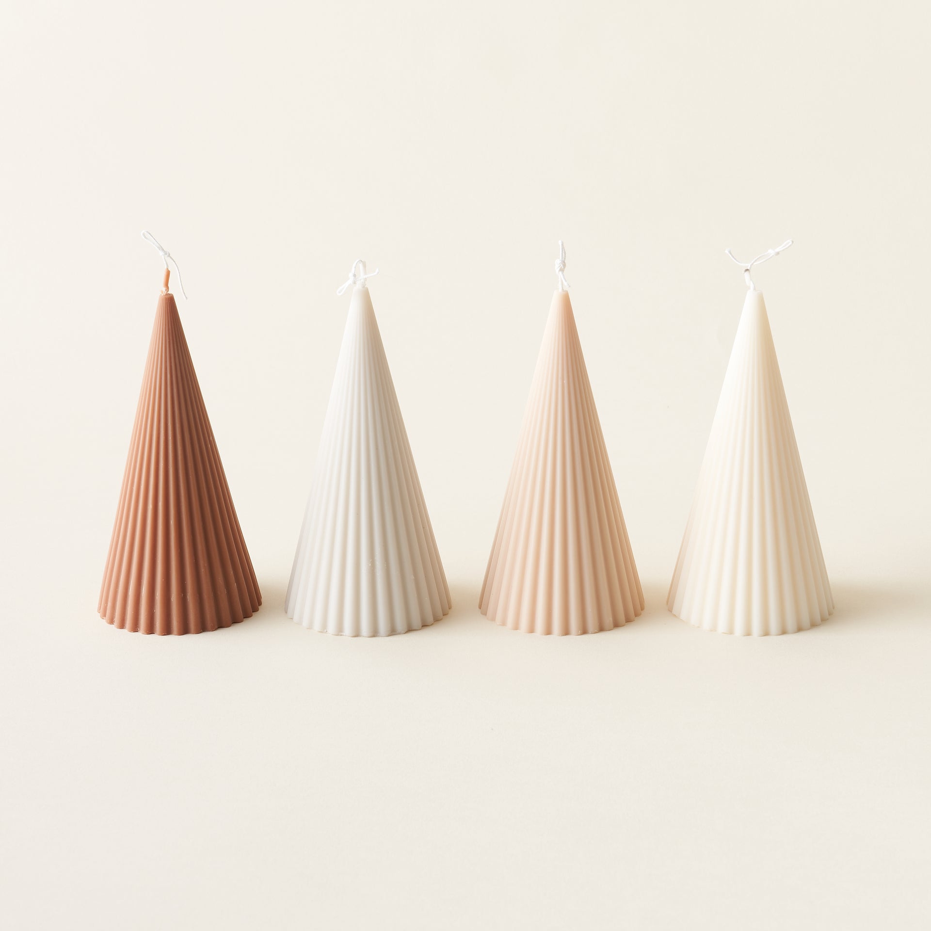 A ribbed, sculptural Christmas tree-shaped candle made from eco-friendly soy wax.