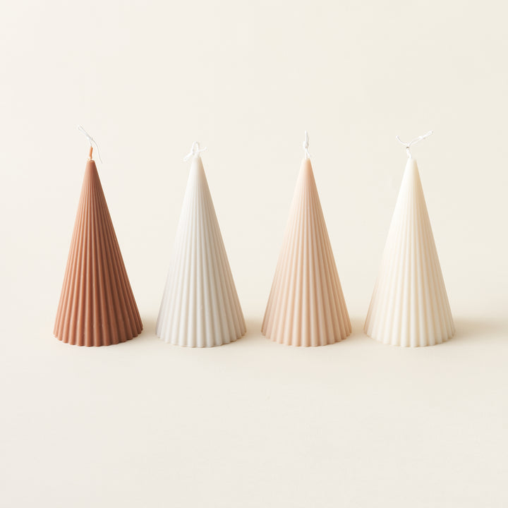 A ribbed, sculptural Christmas tree-shaped candle made from eco-friendly soy wax.
