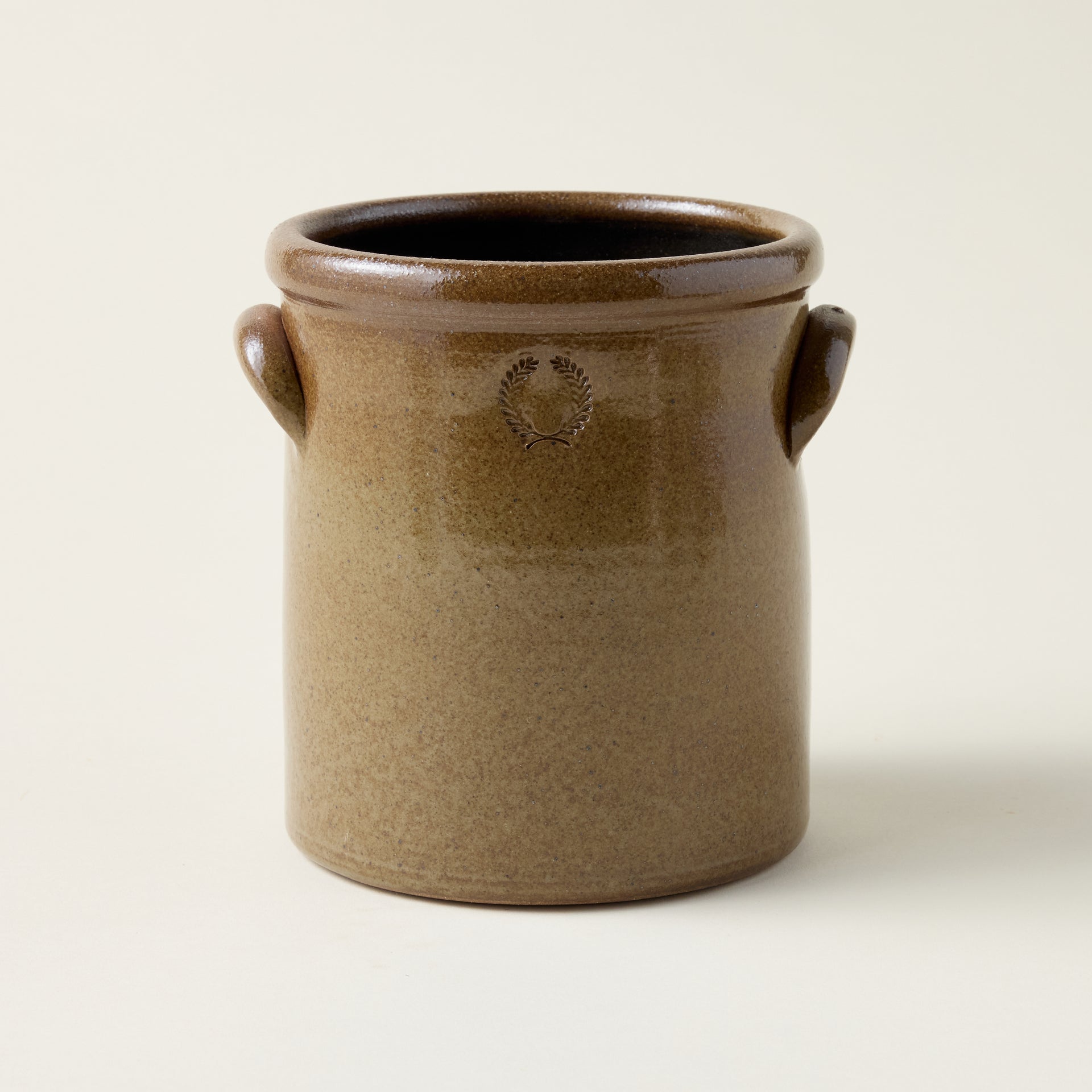 Handcrafted agrarian crock with a warm earthy brown exterior, natural iron flecking, and a hand-stamped handle.