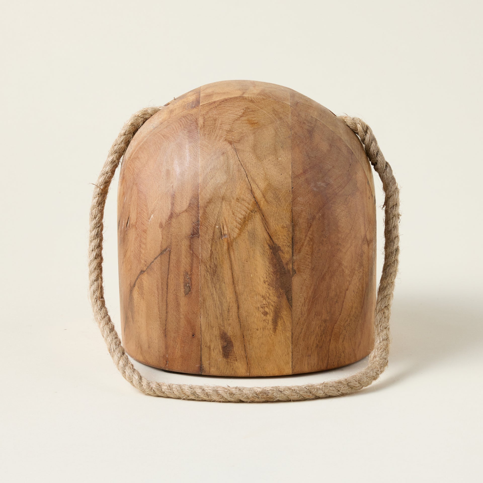 Salvaged wood doorstop with a geometric shape and a woven rope handle, styled with nautical charm.