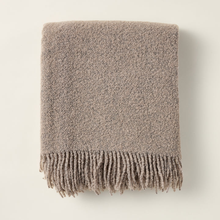 Wool boucle throw with a rich, textural weave, styled for a cozy and layered look.