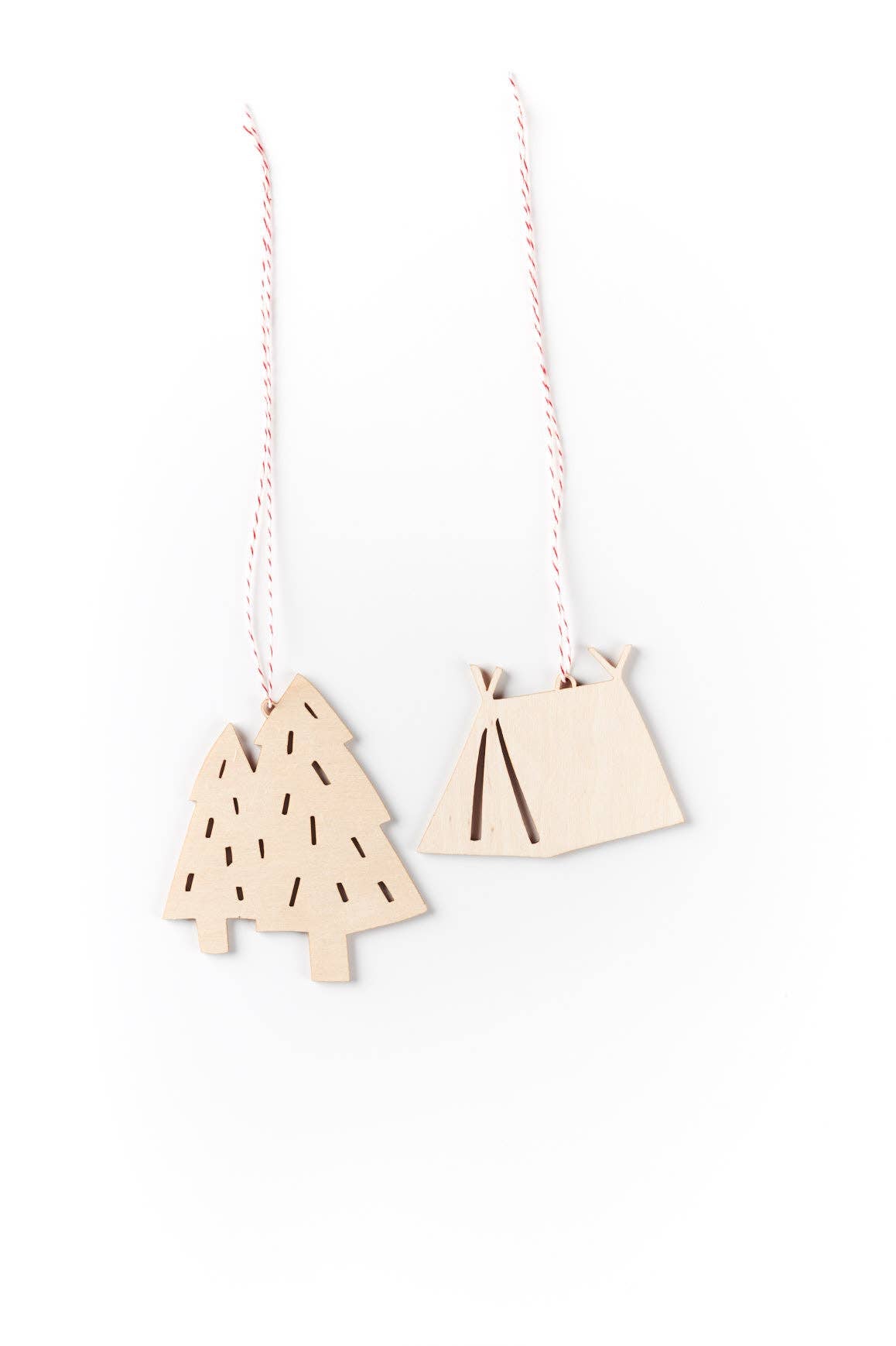 A set of two laser-cut wooden ornaments with intricate holiday designs.