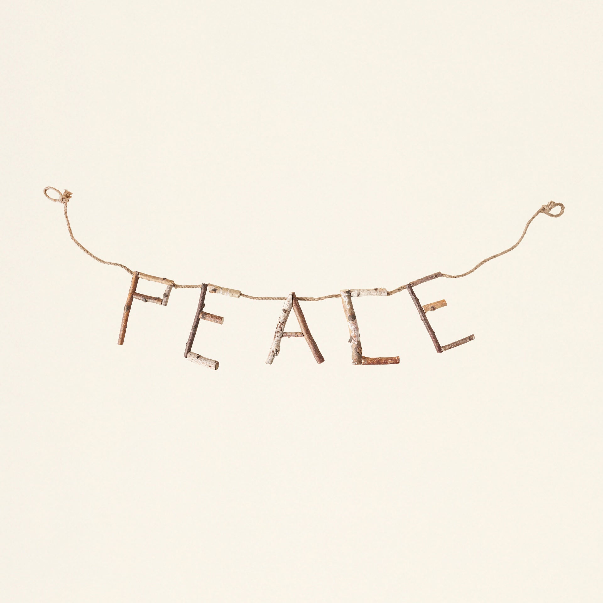A decorative banner with the word "peace" cut from natural birch wood.