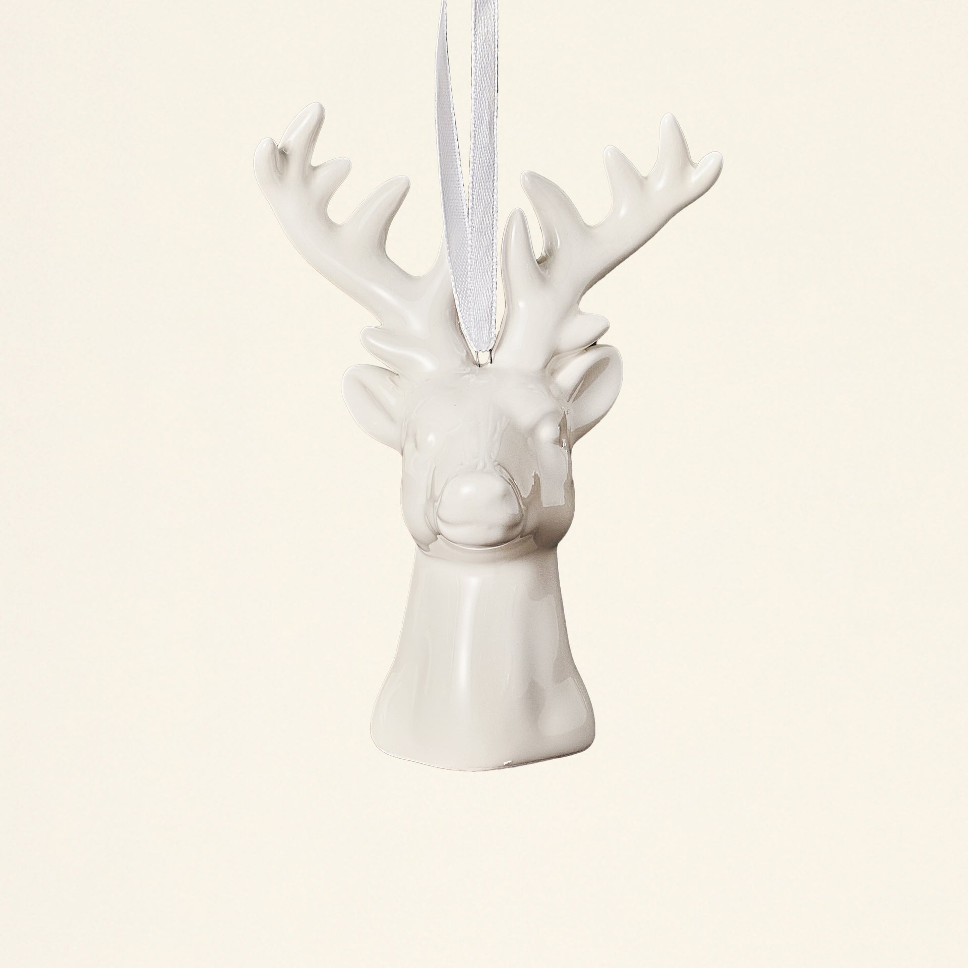 A white ceramic reindeer bust ornament with a glossy glaze.