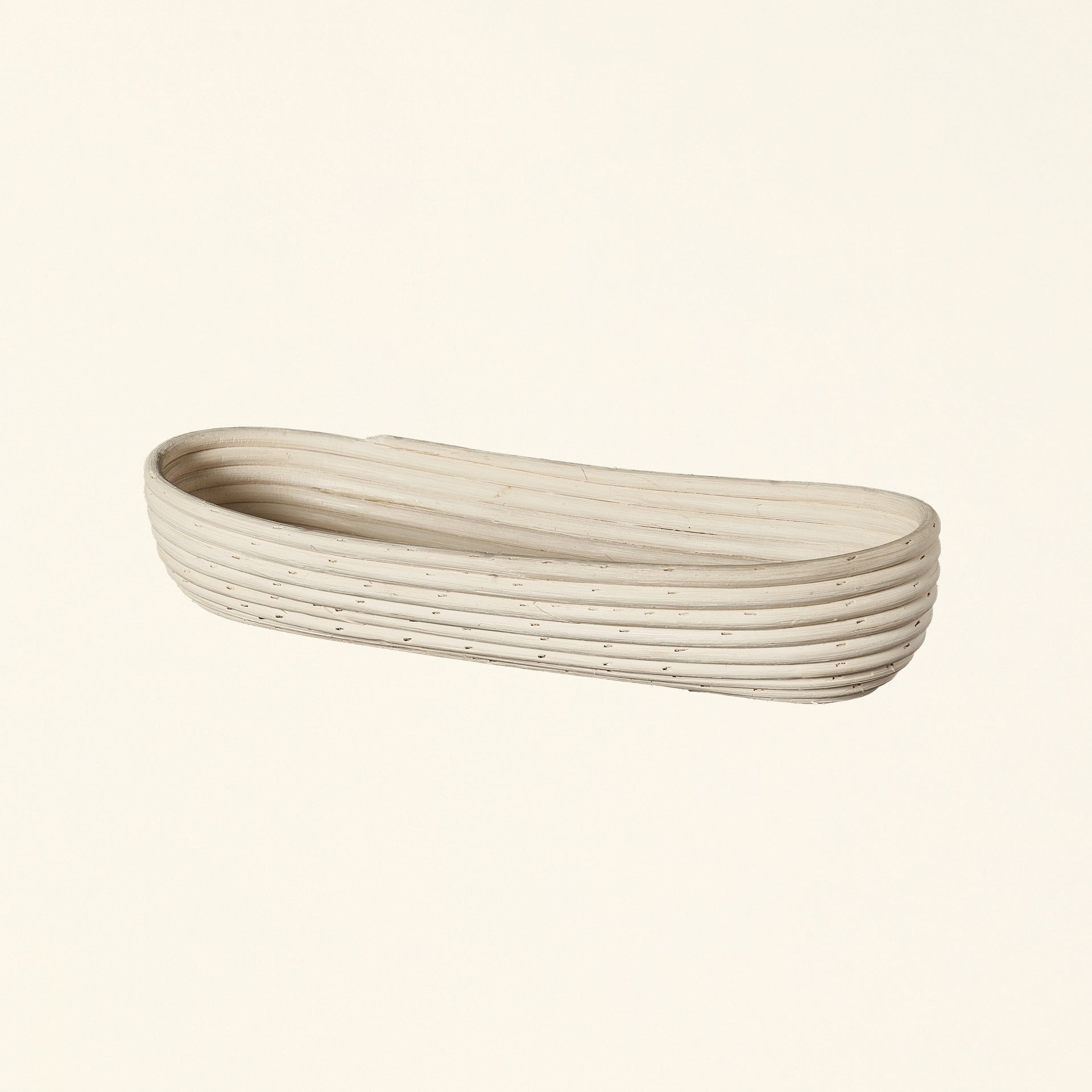 Natural rattan basket with a long, thin shape.