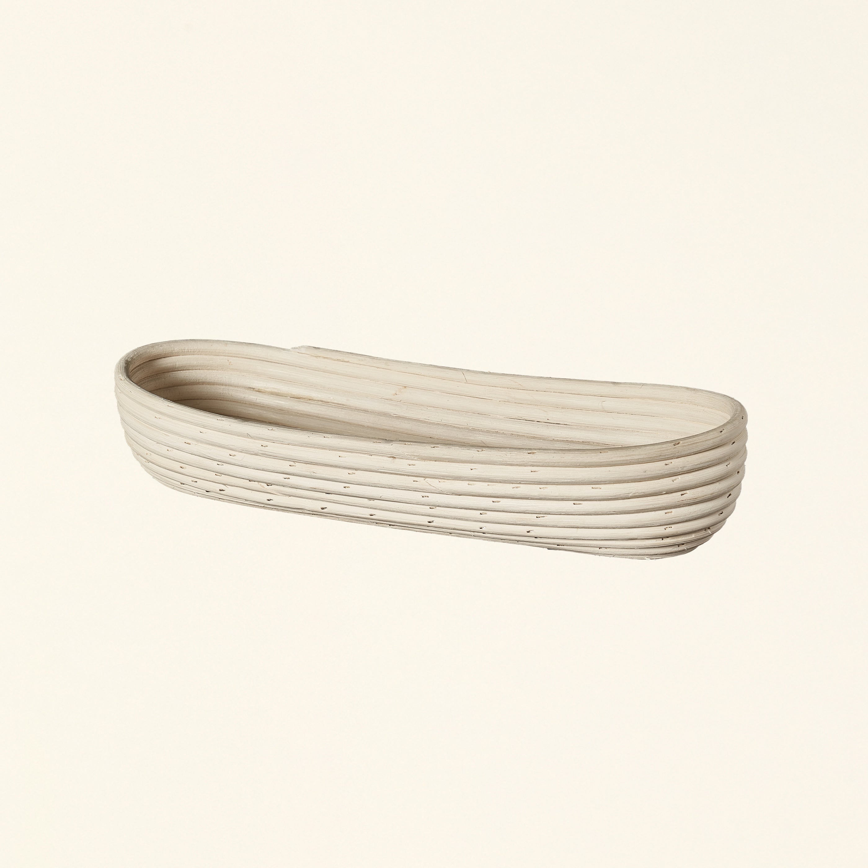 Natural rattan basket with a long, thin shape.