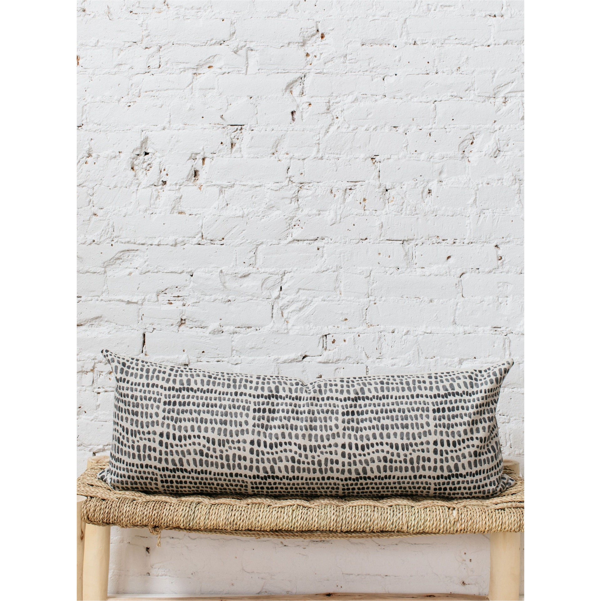 A large lumbar pillow cover in a deep coal color, displayed flat to show its plush texture and simple, clean design.