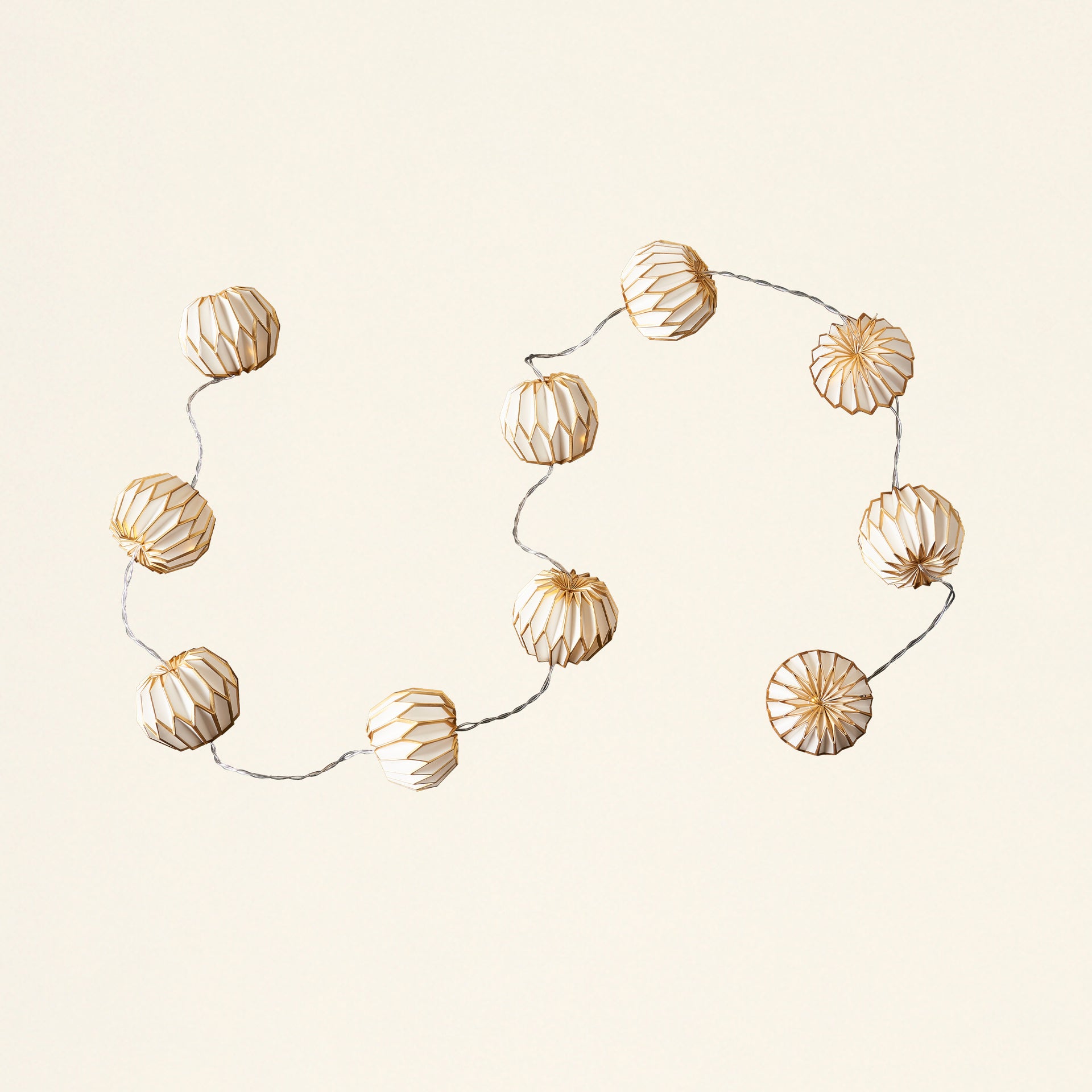 A decorative paper garland with LED lights, in a white and gold color scheme.