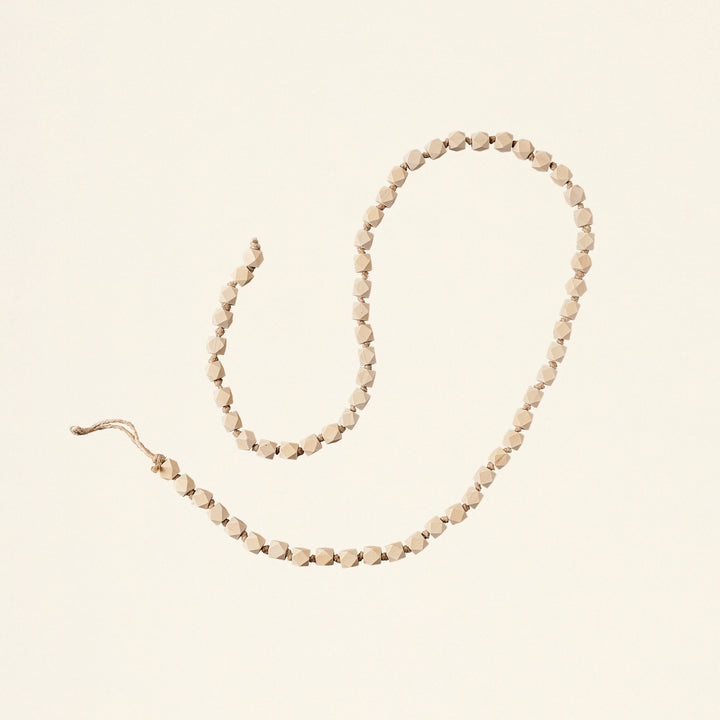 A decorative garland with geometric-shaped wooden beads.